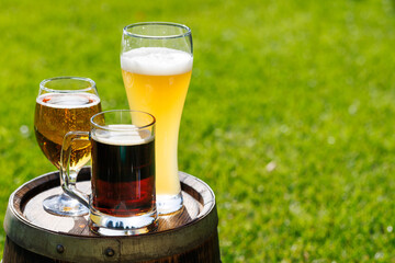 Variety of beer glasses on rustic wooden barrel