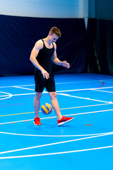 young pumped up guy sportsman prepares to serve the ball during a volleyball game or match