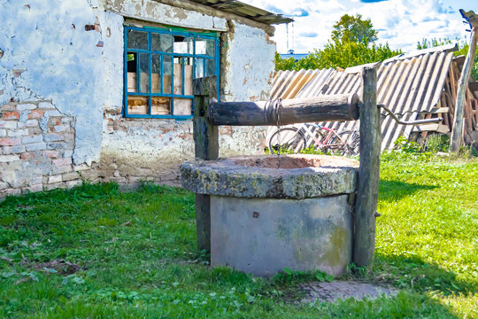 Old well with iron bucket on long forged chain for clean drinking water