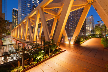 High Line public park with a timber wooden truss bridge in evening. Chelsea, Manhattan, New York...