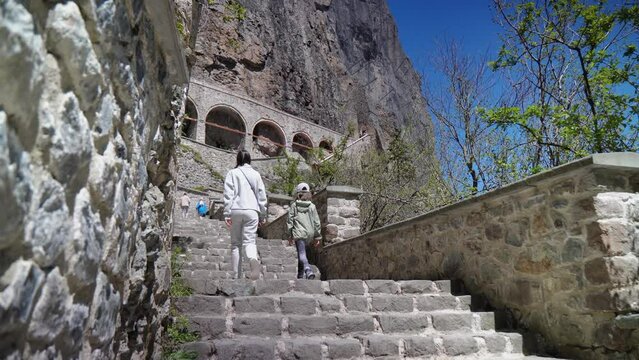 Captivating visit to the historic Panagia Sumela Monastery in Turkey. A mother and daughter ascend the picturesque stairs, exploring the iconic tourist destination.