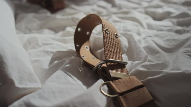 Close-up shot of part of bed in psychiatric hospital with brown belts to restrain insane patients