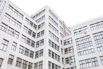 Corner of a high-rise building, white, with many windows