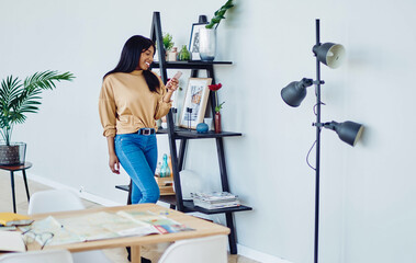 positive dark skinned woman satisfied with free time at comfortable apartment