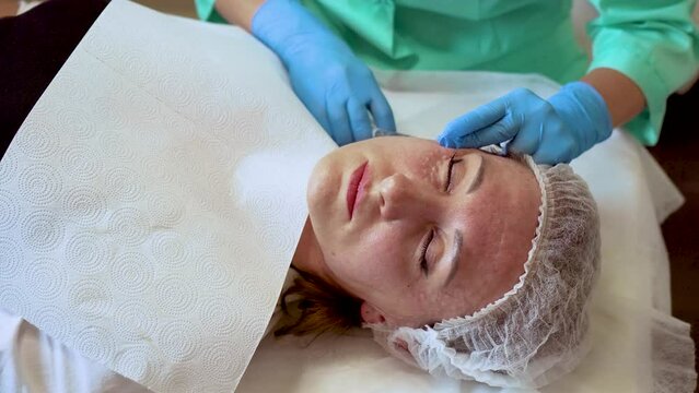 Middle adged woman getting neurotoxin injection at beauty parlor, anti aging skin treatment. Female enjoying facial treatment, moisturizing and rejuvenating medical procedures