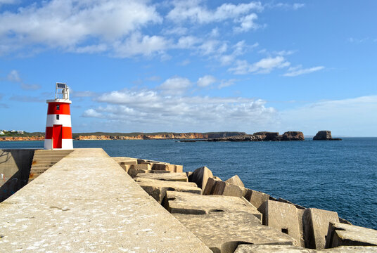 
artificial reef with white and red lighthouse protecting the ocean port
