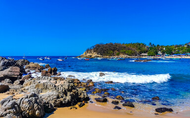 Beach sand blue turquoise water waves rocks panorama Puerto Escondido.