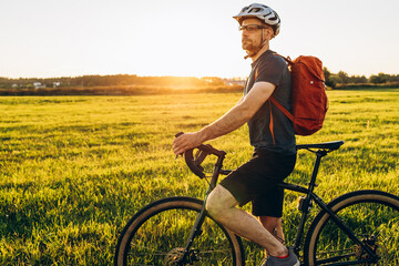 Male caucasian cyclist standing with his bike. Young pretty athletic man with bicycle outdoor. Active sporty people concept image - Powered by Adobe