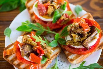 Prepared sandwich with tomatoes, mozzarella and fried eggplant with mushrooms.