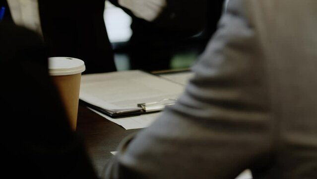 Closeup shot of business investors reading profit statistics paper sheets in boardroom. Busy season review accountant reports. People count numbers to create new startup.