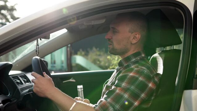 A man drinks alcohol while driving a car. Depression and stress led to alcoholism.
