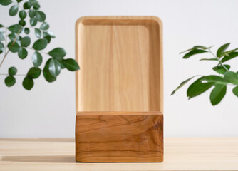 Minimal wood podium table top blurred green leaf plant on white empty space nature background.Beauty cosmetic natural product modern wooden display.