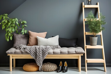 Rustic wood bench with grey cushion, beige and black pillows and woolen blanket, ladder against dark wall with copy space. Scandinavian, farmhouse interior design of modern entrance hall with door.