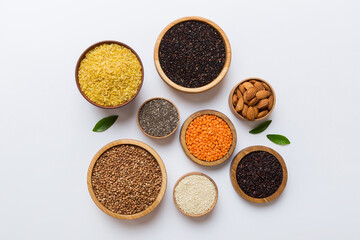 Various superfoods in smal bowl on colored background. Superfood as rice, chia, quinoa, lentils, nuts, sesame seeds, almonds. top view copy space