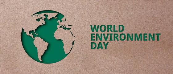 Brown paper cut out shape of the world on a green background with the text World Environment Day. Earth conservation concept environmental protection