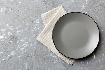 Top view on colored background empty round gray plate on tablecloth for food. Empty dish on napkin...