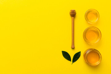 Honey jar with wooden honey dipper on white background top view with copy space. Delicious honey bottle