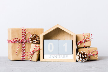 1 january. Christmas composition on colored background with a wooden calendar, with a gift box, toys, bauble copy space