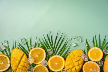 Summer colorfull concept with tropical fruits, ice and leaves on green background, flat lay, top...