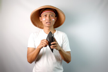 Indonesian farmer showing shocked expression when looking to his empty wallet