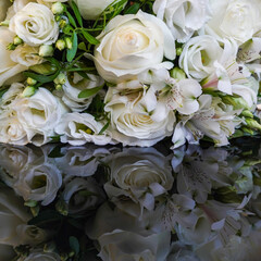 Weißer Blumenstrauß aus Rosen, Lisianthus und Alstromerien auf dunklem Untergrund gespiegelt,...