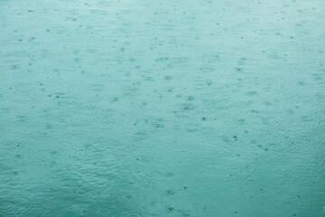 Background water surface with circles of raindrops. Water ripple texture.