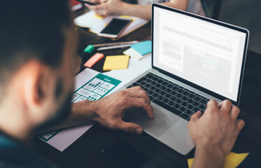 Crop man working on laptop in cafe