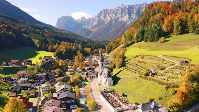 4k drone flight moving to the side footage (Ultra High Definition) of Parish Church of St. Sebastian. Sunny morning view of Bavarian Alps, Ramsau village, Germany, Europe.