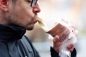  Man eating kürtoskalac or chimney cake © NoemiEscribano