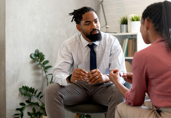 A psychotherapist session with a patient. African-American women and men have a meeting.  - Powered by Adobe