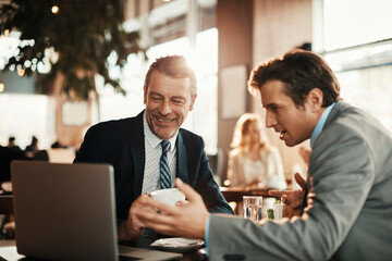 Two businessmen on a business meeting in an indoor cafe in the city