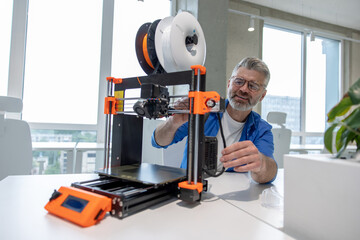 Man designer printing design using 3D printer in office.