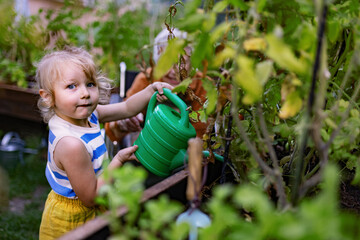 Portrait of a little adorable girl helping her grandmother in the garden. © Halfpoint
