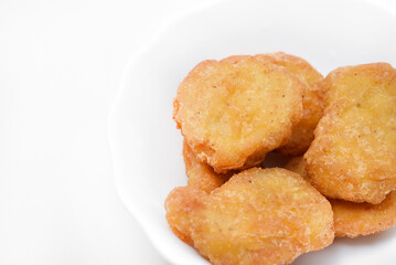 Chicken nuggets on a white plate. Fried chicken meat in pieces.