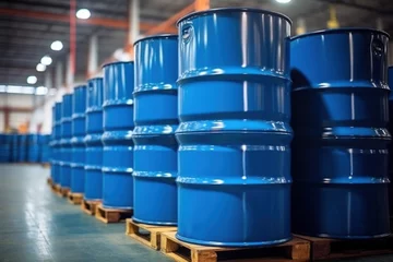 Fotobehang Blue barrels on pallets contain liquid chemicals in the warehouse. Industrial background. © Anna