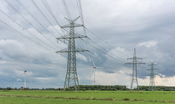 Neue Stromtrasse mit Strommasten an einem Windpark