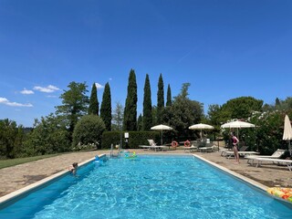 Kinder spielen am Pool in der Toskana. 