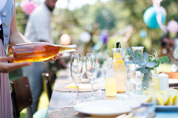Close up shot of pouring wine at summer garden party.