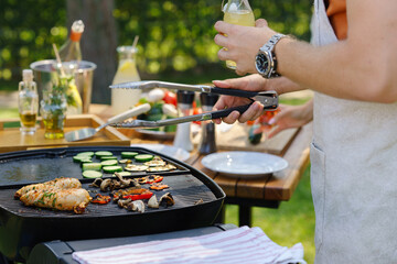 Close up of a man grilling at a bbq garden party.