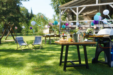 Summer garden party in a beautiful garden with a large wooden deck in the background.