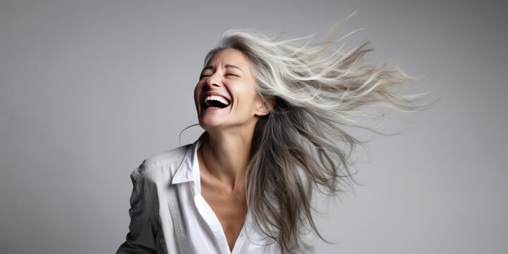 Middle age woman with white hairs smiling, laughing 