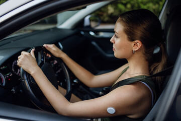 Woman with diabetes monitoring her blood sugar during car drive.