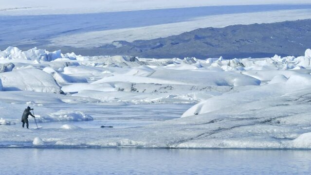 Glacier lagoon with paddle boarder in artic