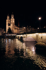 Zurich, The church Grossmunster. Zurich. Switzerland. Image of Zurich cityscape at night, evening city lights, city at night. Popular travel destination. The old town of Zurich.