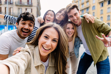 Young group of happy people having fun together outdoors. Multicultural student friends taking...