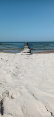 Morska plaża z falochronem. 