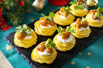Christmas appetizer. Baked mashed potatoes with curd cheese and pickled mushrooms on the festive table.