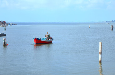 red boat in the middle of the sea during the collection of mussels and clams