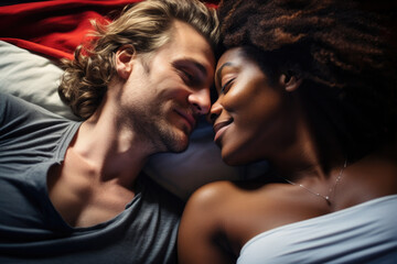 A dark-skinned beautiful girl and a white guy lie in an embrace, love and feelings.