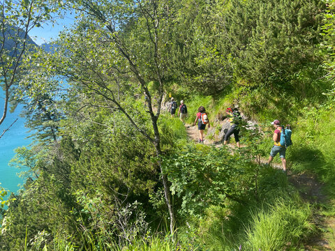 Eine Wandergruppe geht auf dem Geisalmsteig am Achensee während einer Alpenueberquerung